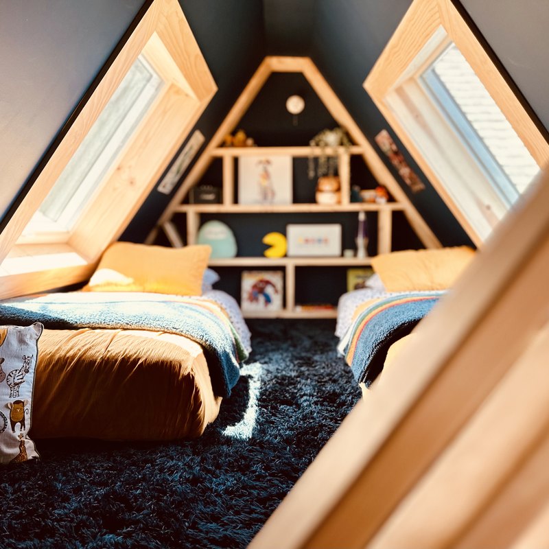 Kids' attic bedroom with twin beds and skylights